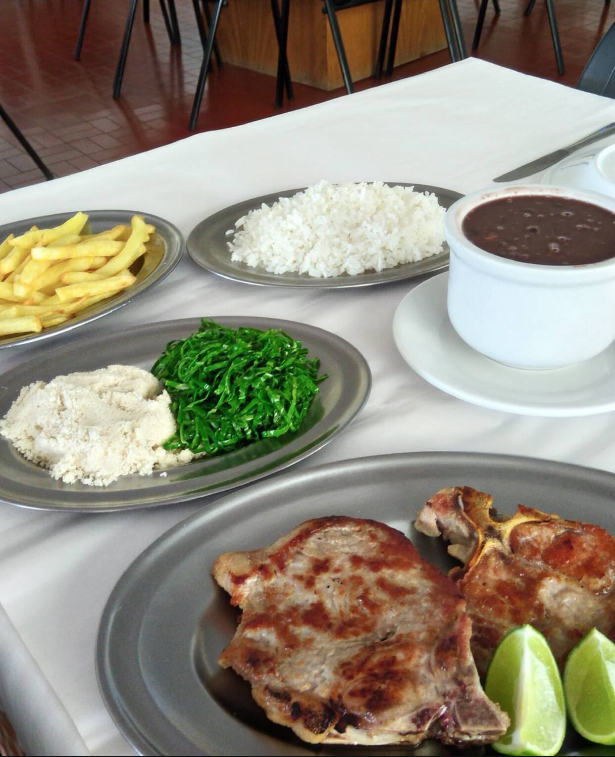 Prato de comida caseira do Restaurante Pipo: bisteca grelhada com arroz, feijão, farofa e couve